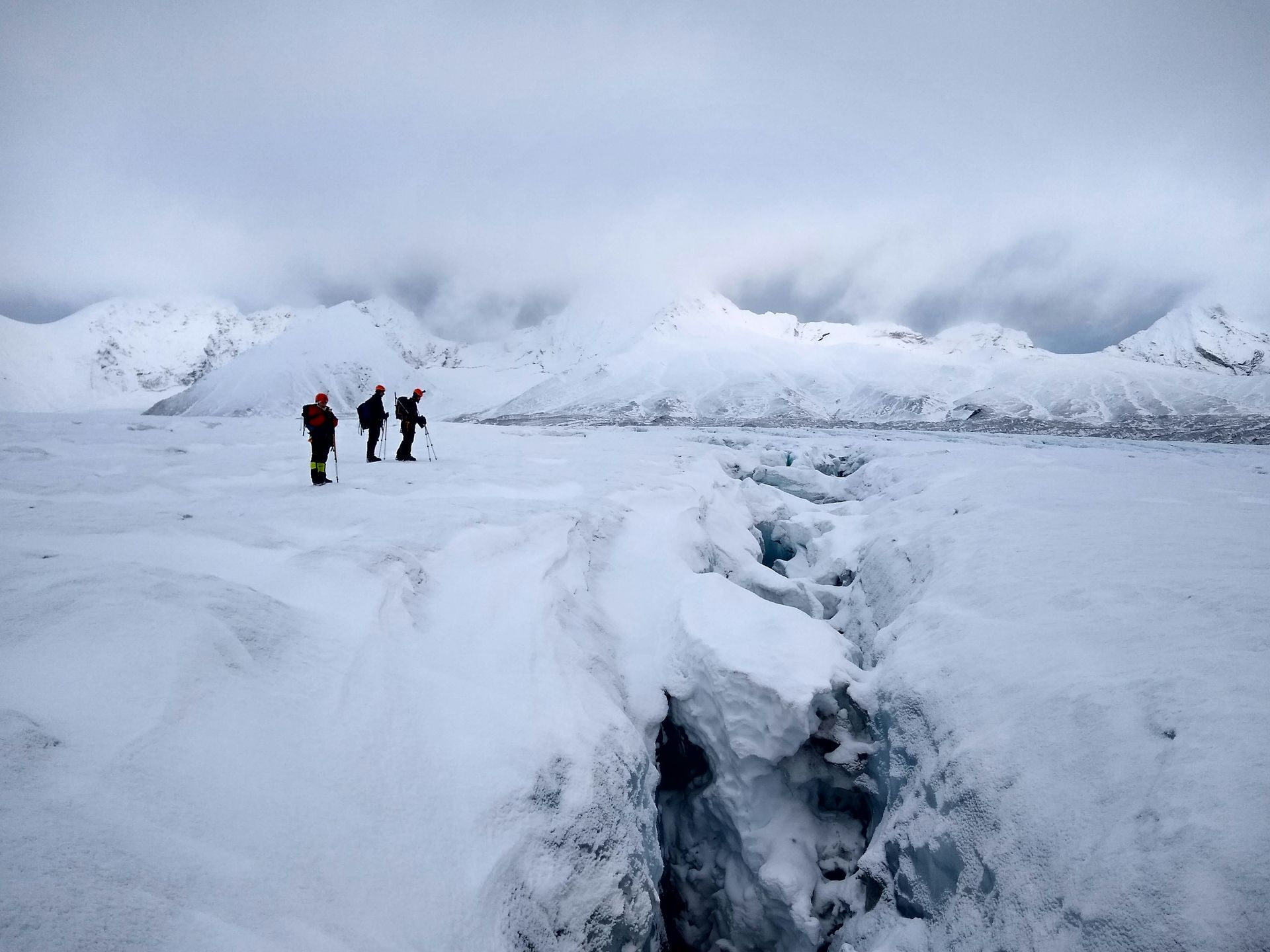 A group of people standing on top of a snow covered mountain.