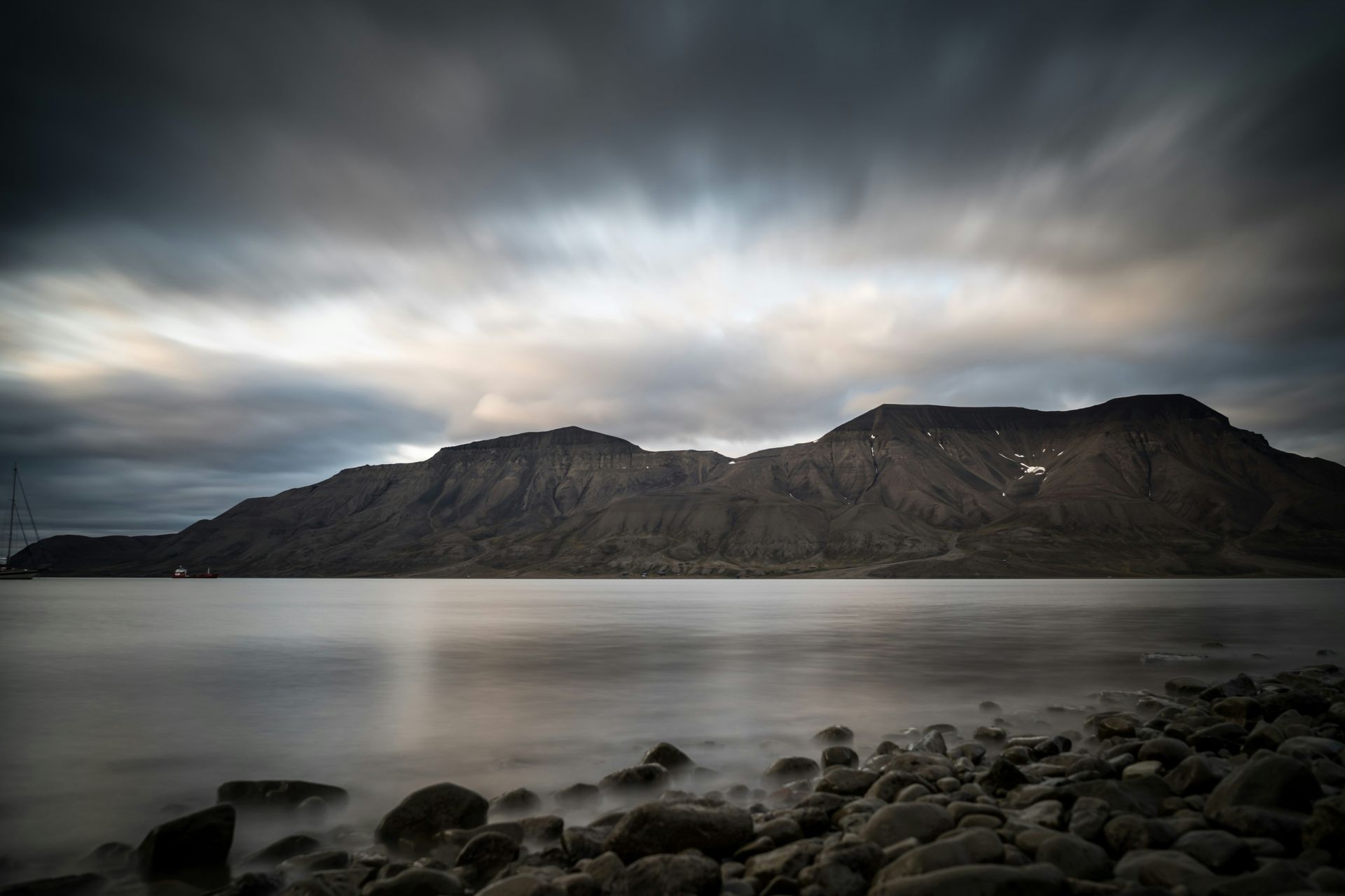 A long exposure photo of a lake with a mountain in the background.