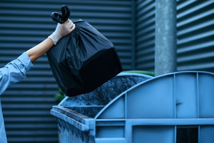 throwing garbage bag in 2-yard bin