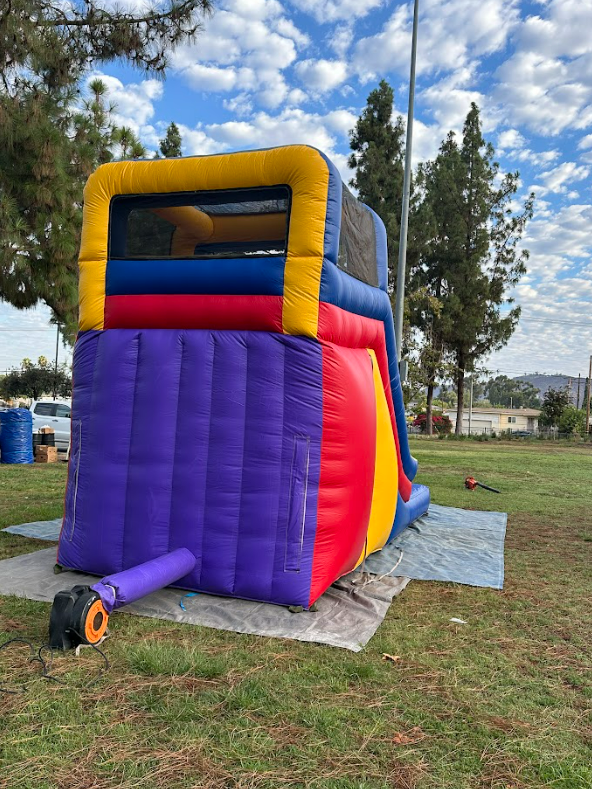 A colorful bouncy house is sitting on top of a lush green field.