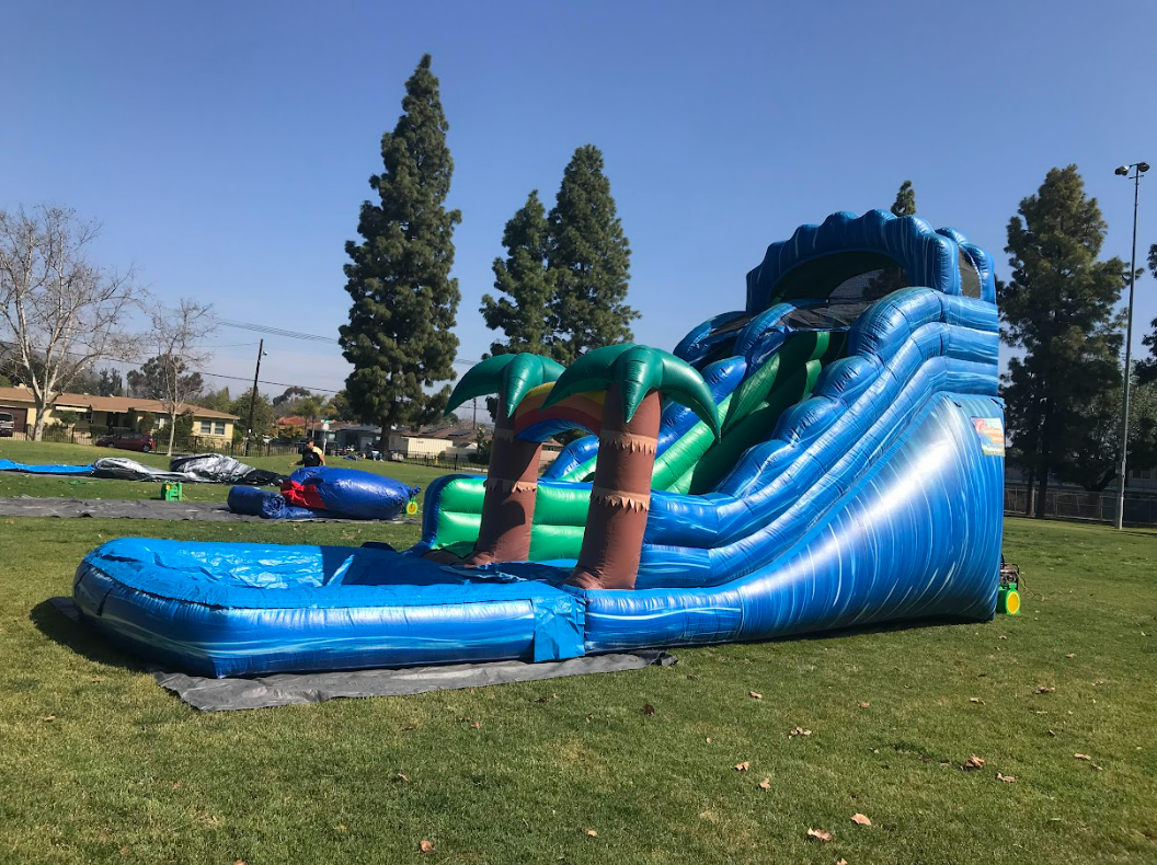 A large inflatable water slide is sitting on top of a lush green field.