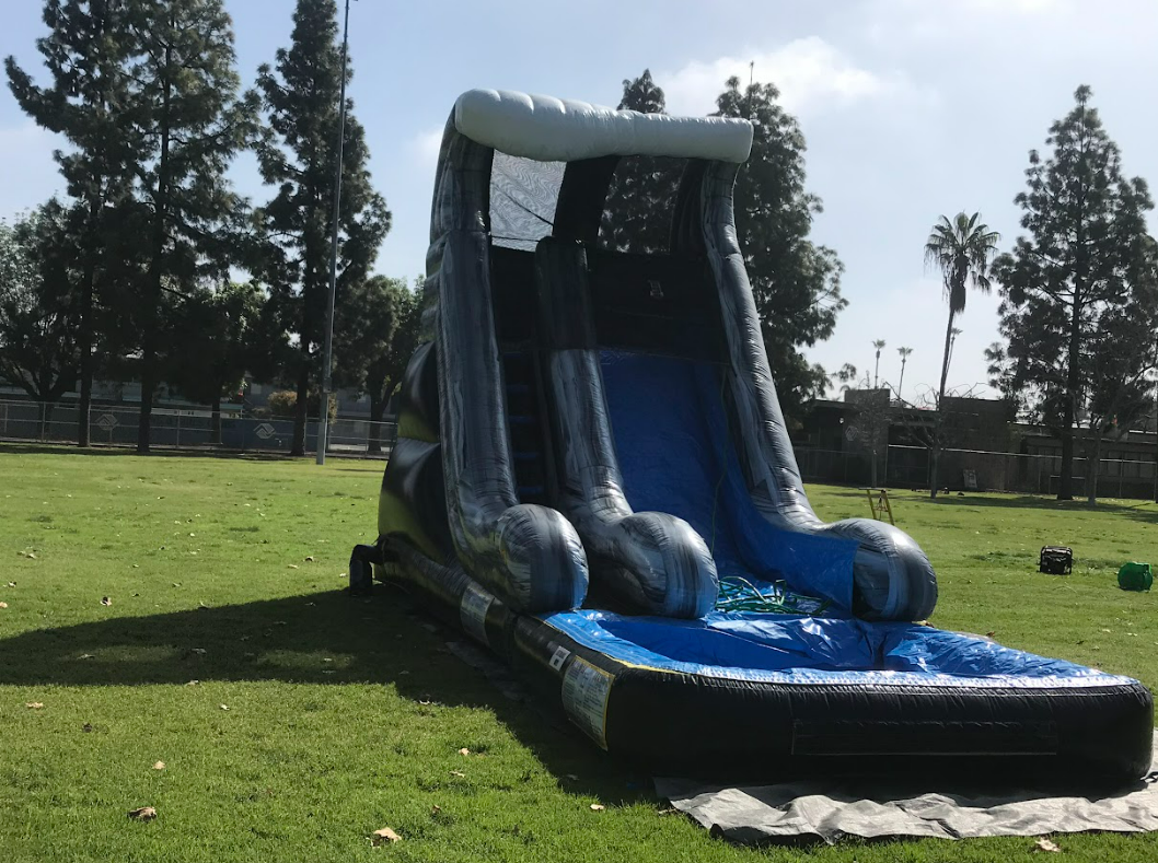 A large inflatable water slide is sitting on top of a lush green field.
