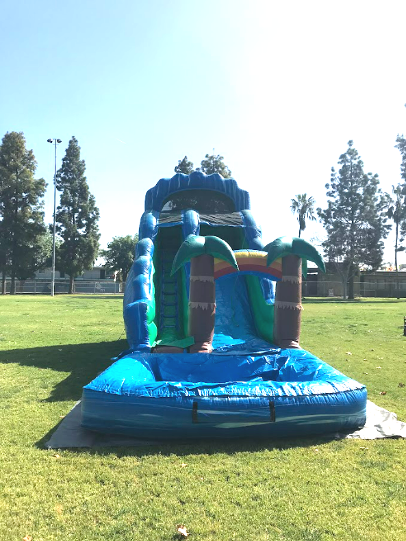 A large inflatable water slide is sitting on top of a lush green field.