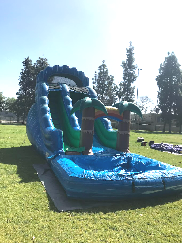 A large inflatable water slide is sitting on top of a lush green field.