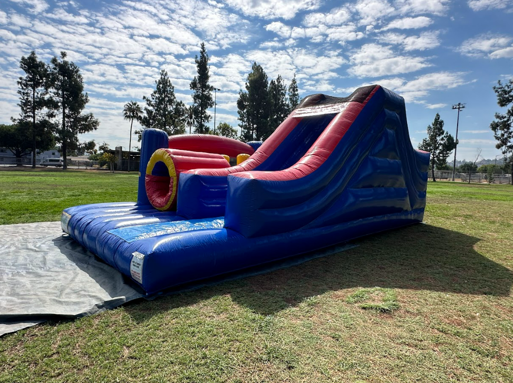 A large inflatable slide is sitting on top of a lush green field.