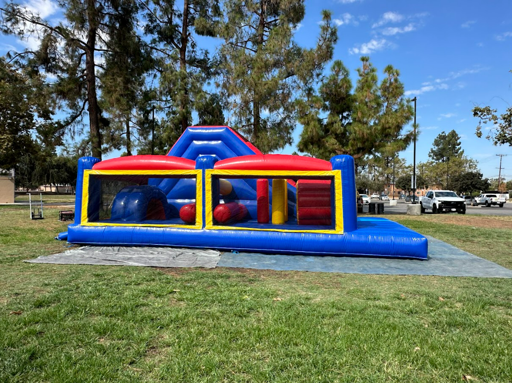 A large inflatable obstacle course is sitting in the middle of a park.