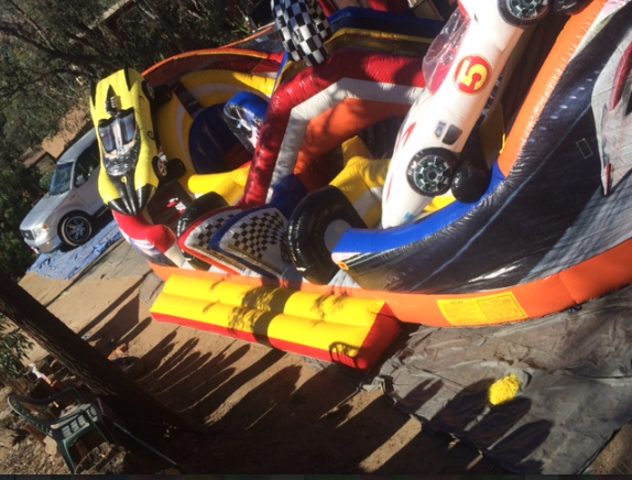 A bouncy house with cars and a number 5 on it