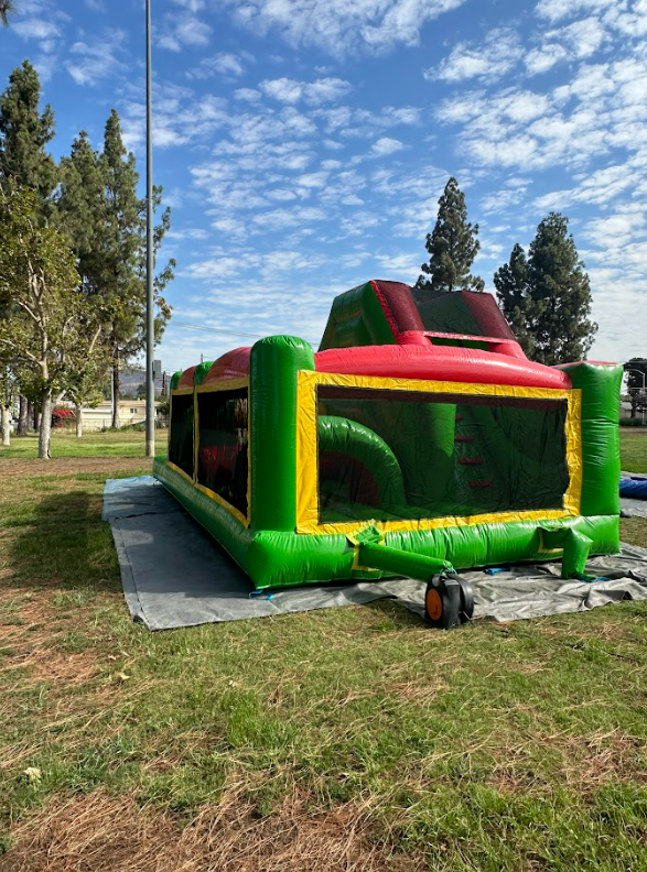 A large inflatable obstacle course is sitting on top of a lush green field.