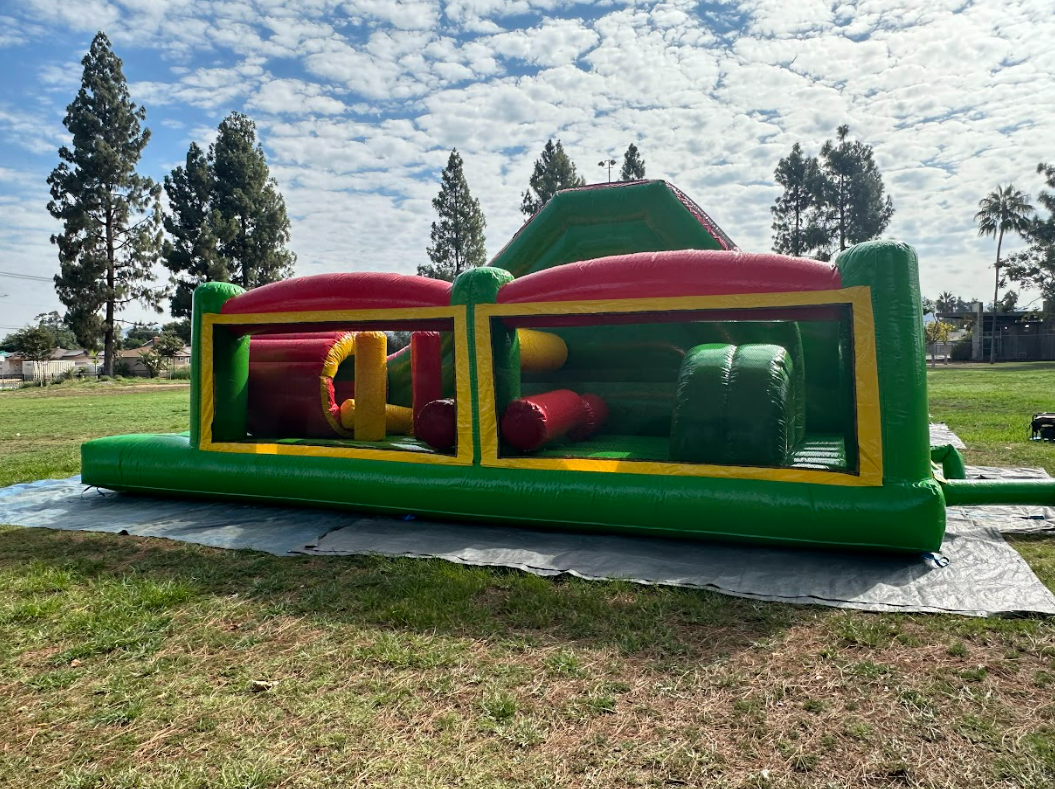 A large inflatable obstacle course is sitting in the middle of a grassy field.