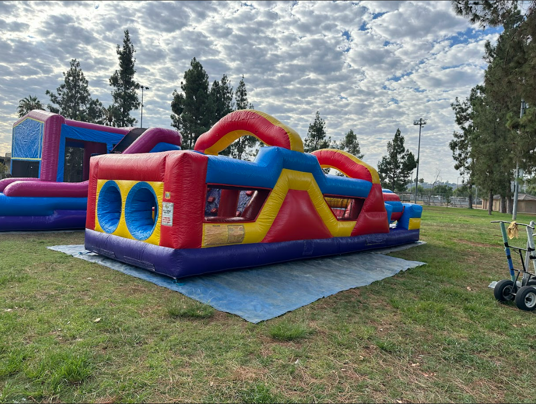 A colorful bouncy house is sitting on top of a lush green field.
