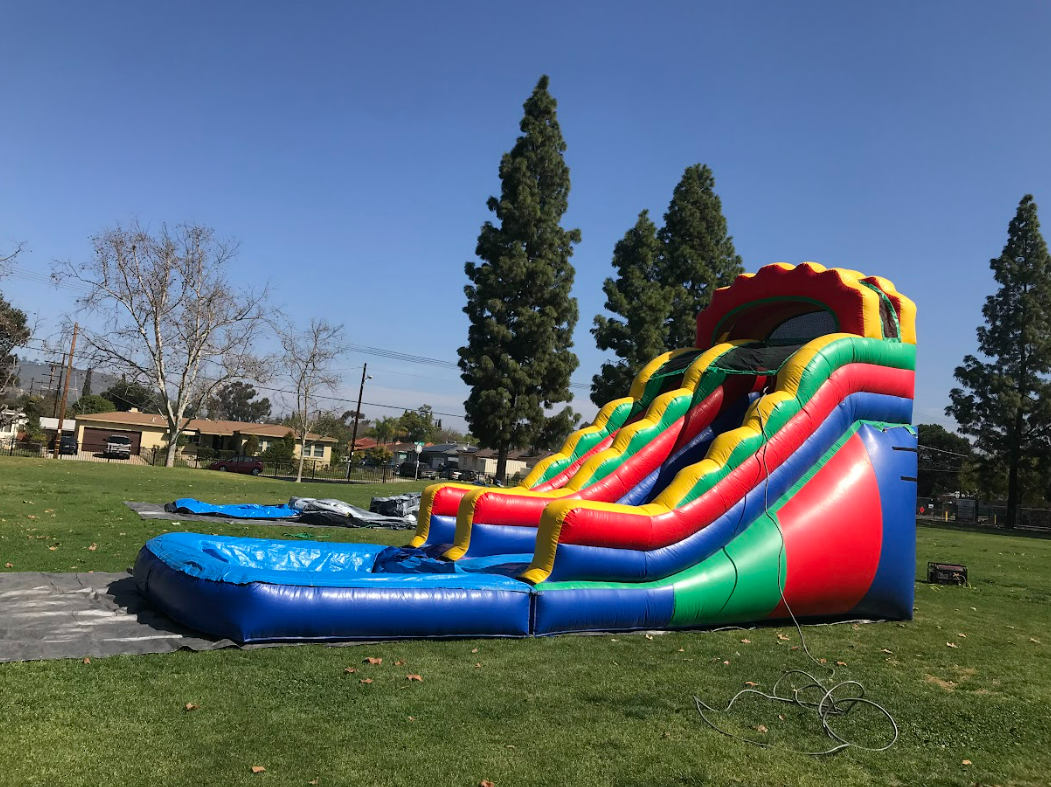 A large inflatable water slide is sitting in the middle of a grassy field.