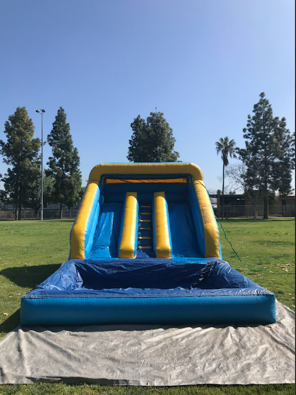 A large inflatable water slide is sitting in the middle of a grassy field.