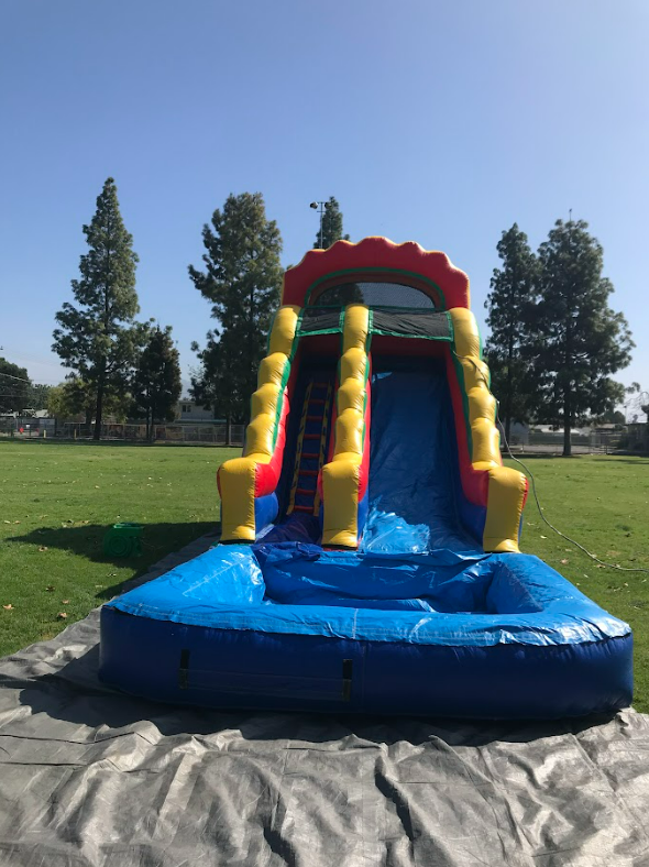 A large inflatable water slide is sitting on the ground in a park.