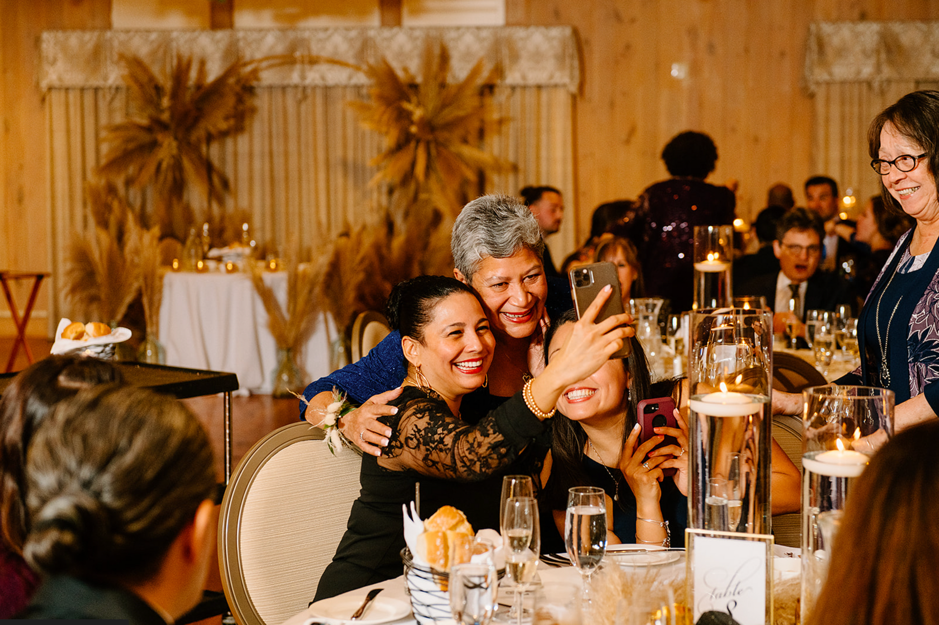 A group of women are taking a selfie at a wedding reception.