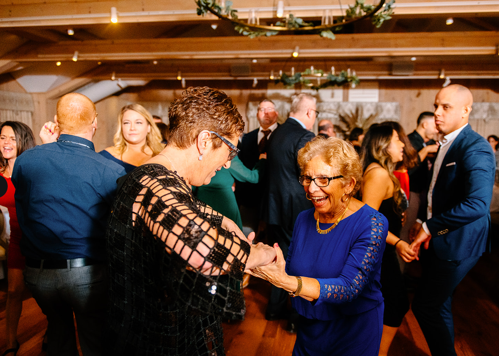 A group of people are dancing together at a wedding reception.