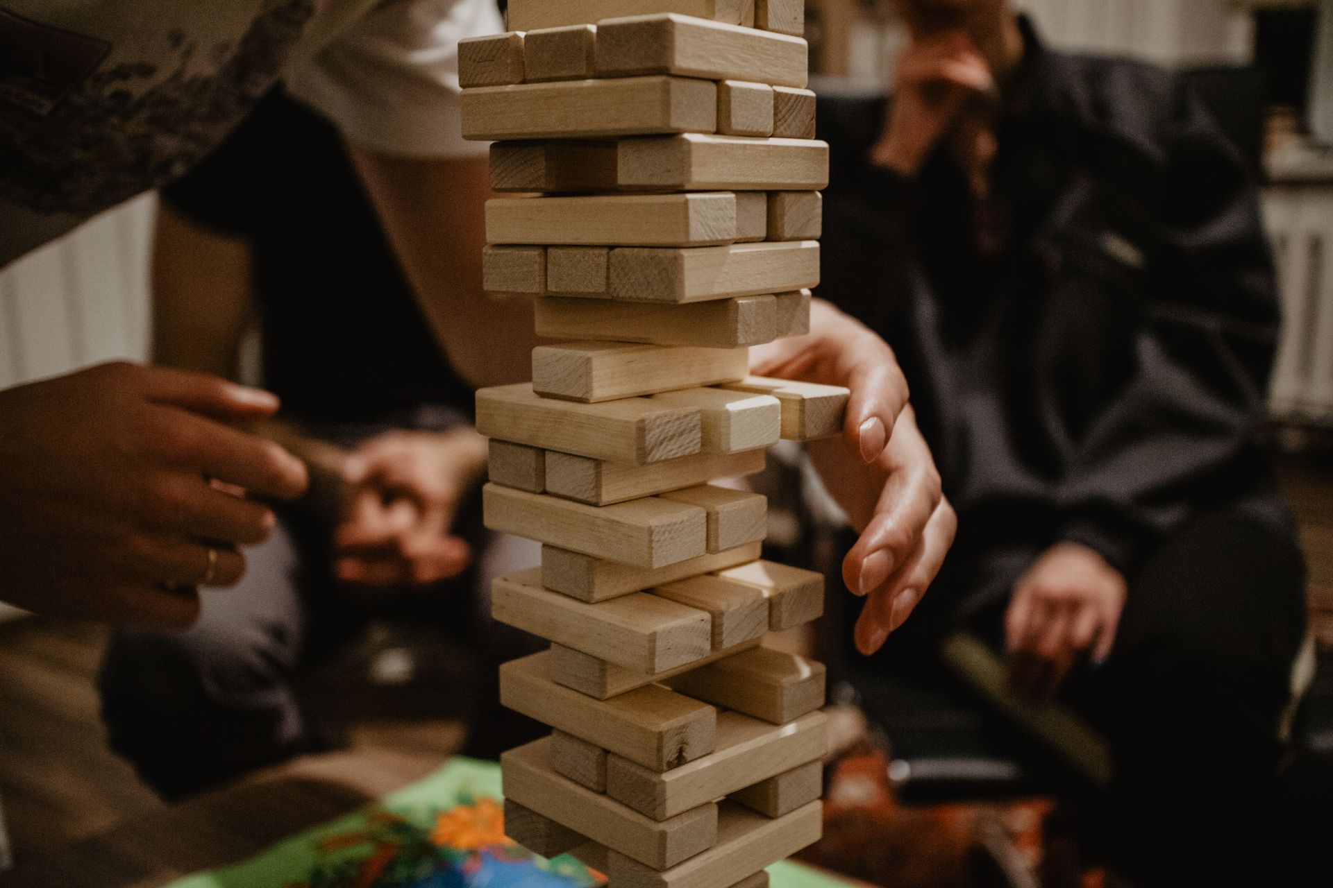 A group of people are playing a game of jenga.