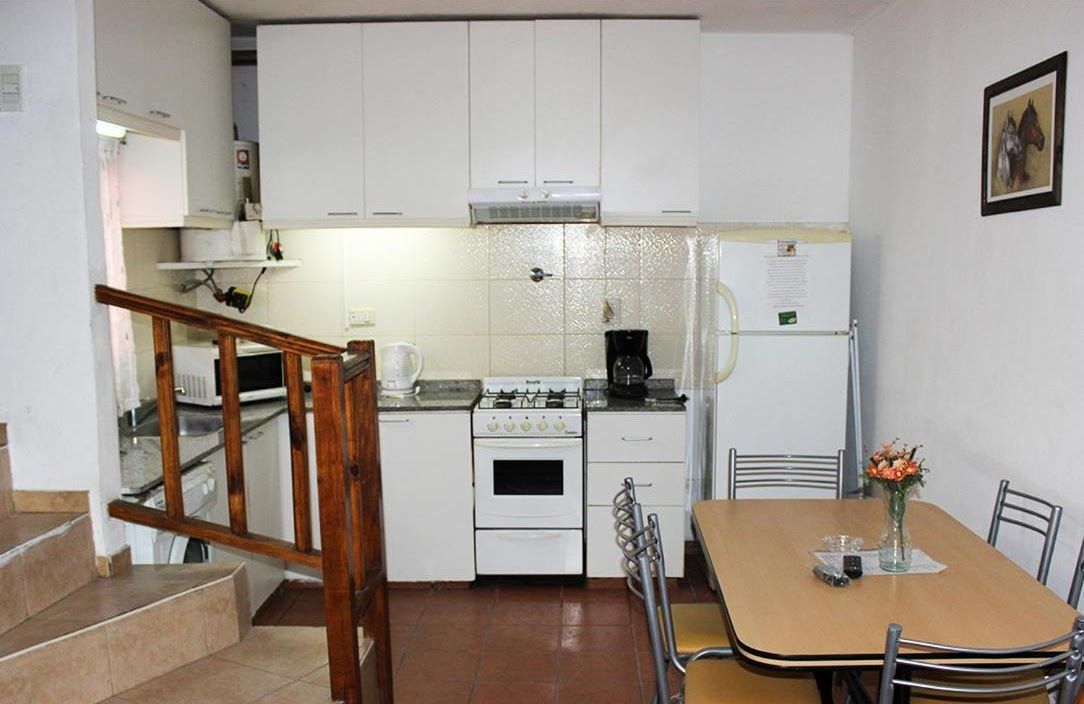 A kitchen with a table and chairs and a refrigerator