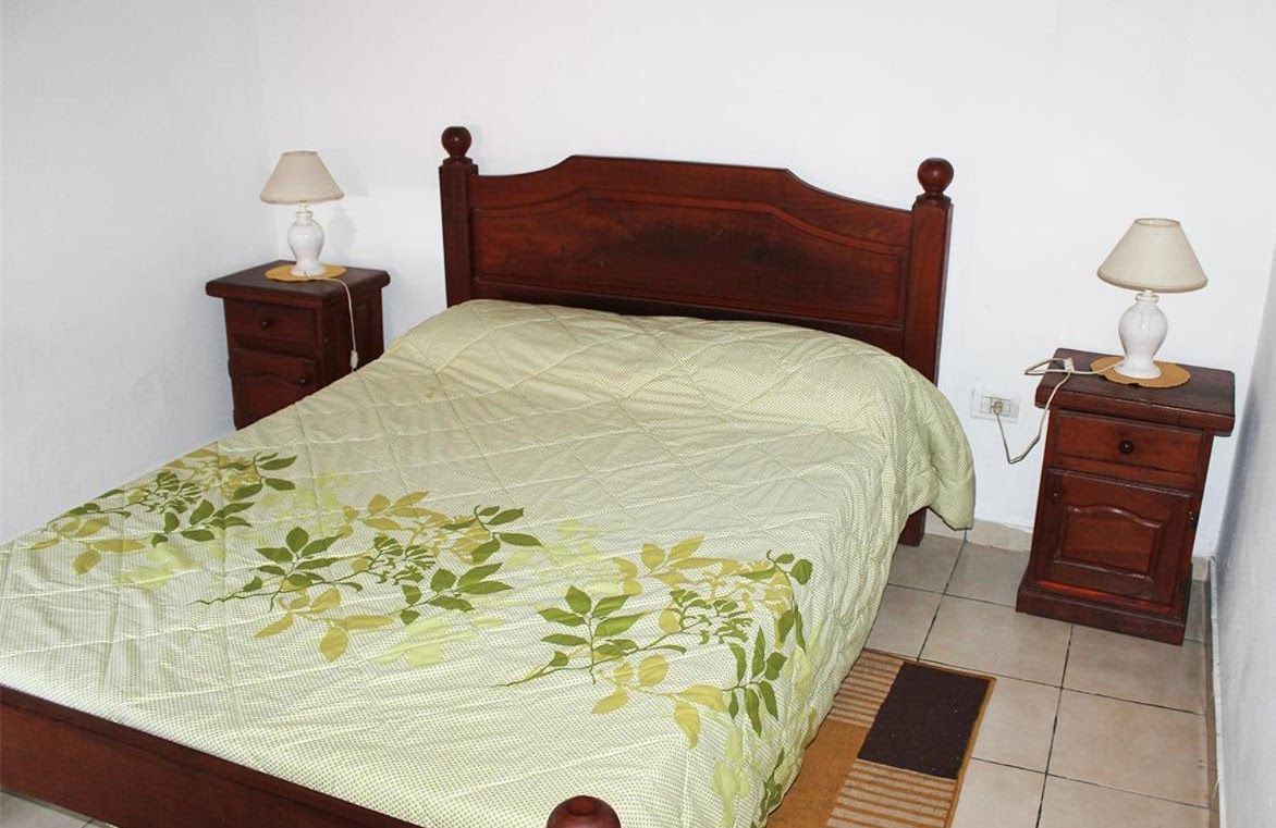 A bedroom with a bed , two nightstands and two lamps