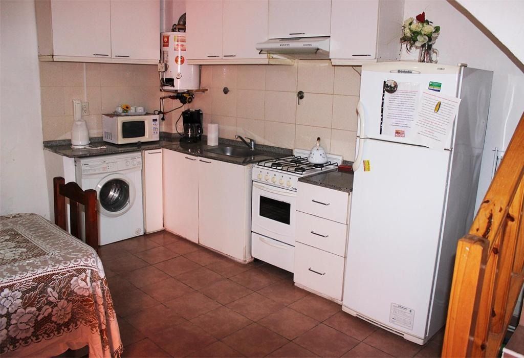 A kitchen with white cabinets and a white refrigerator