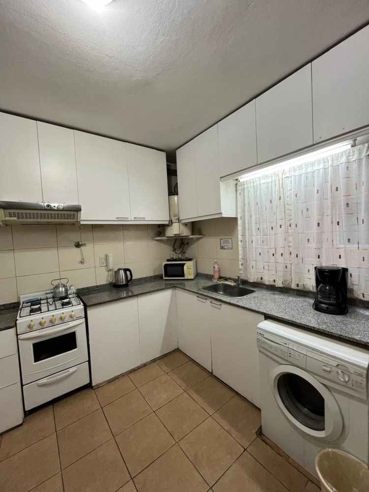 A kitchen with a stove , washer and dryer.
