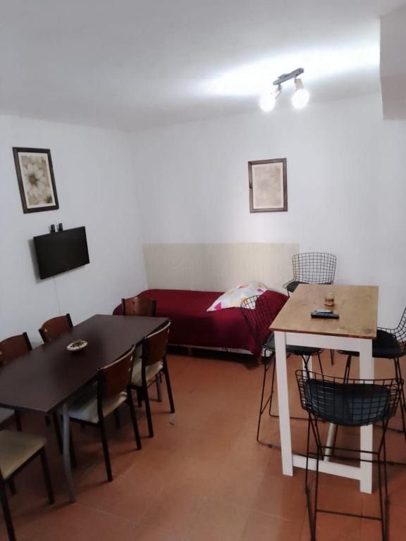 A living room with a table and chairs and a bed