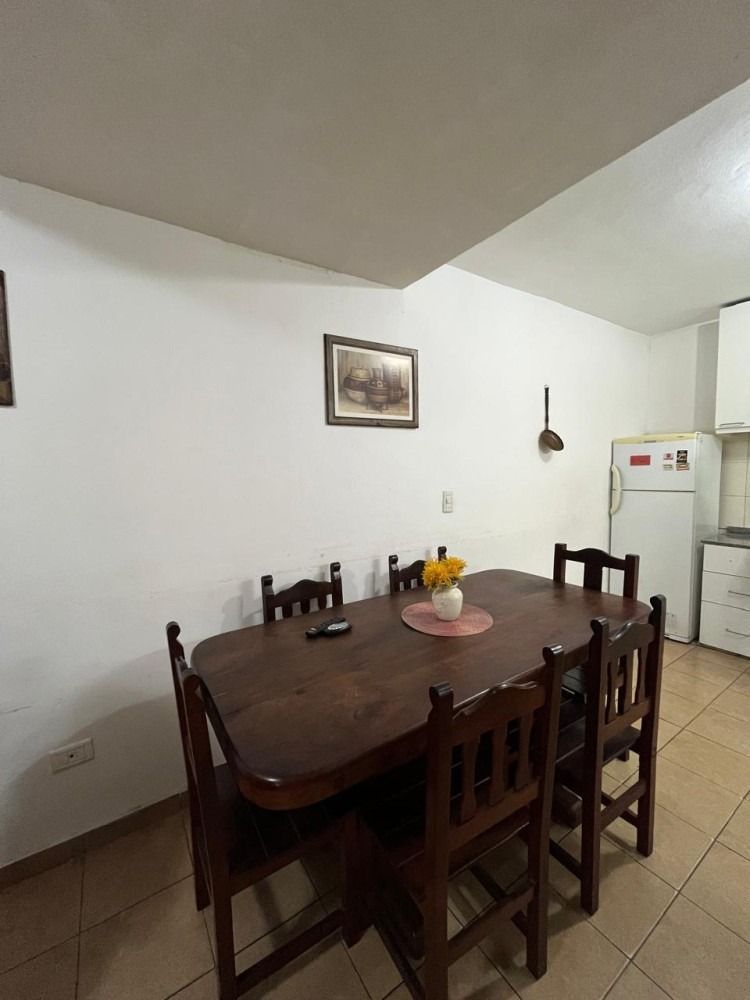 A kitchen with a table and chairs and a refrigerator