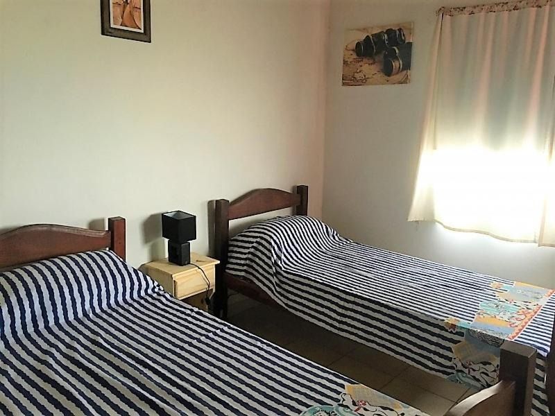 A bedroom with two twin beds and a lamp.