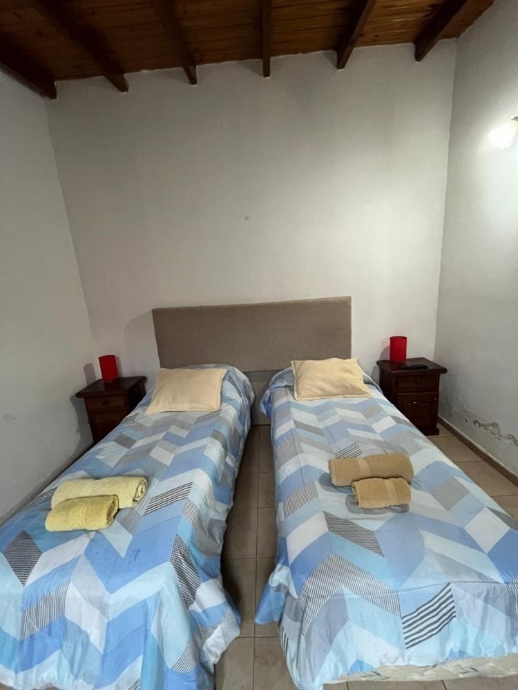 A bedroom with two twin beds and two nightstands.