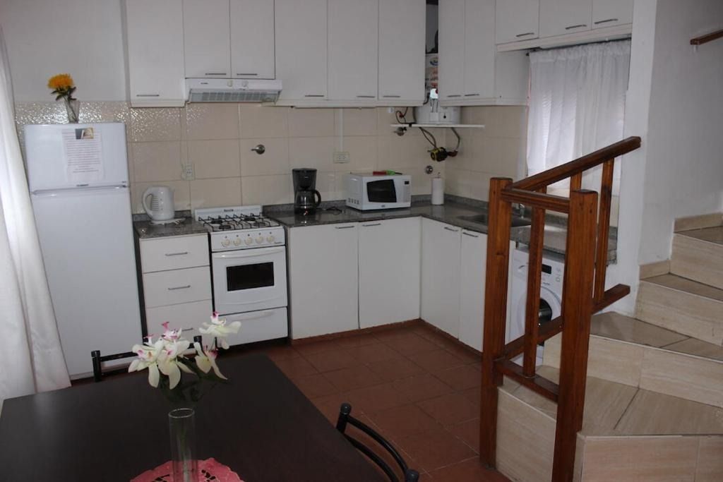 A kitchen with a staircase leading up to the second floor