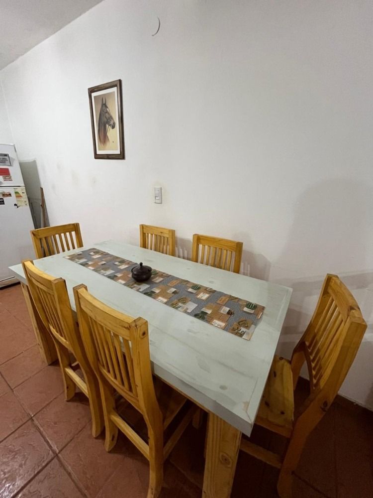 A kitchen with a table and chairs and a refrigerator.