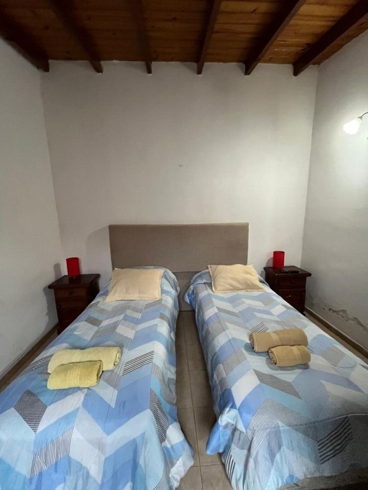 A bedroom with two twin beds and two nightstands.