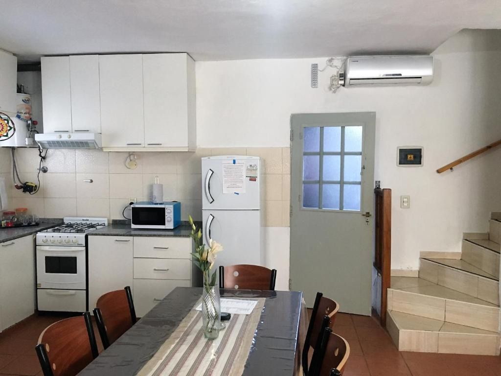 A kitchen with a table and chairs and a refrigerator
