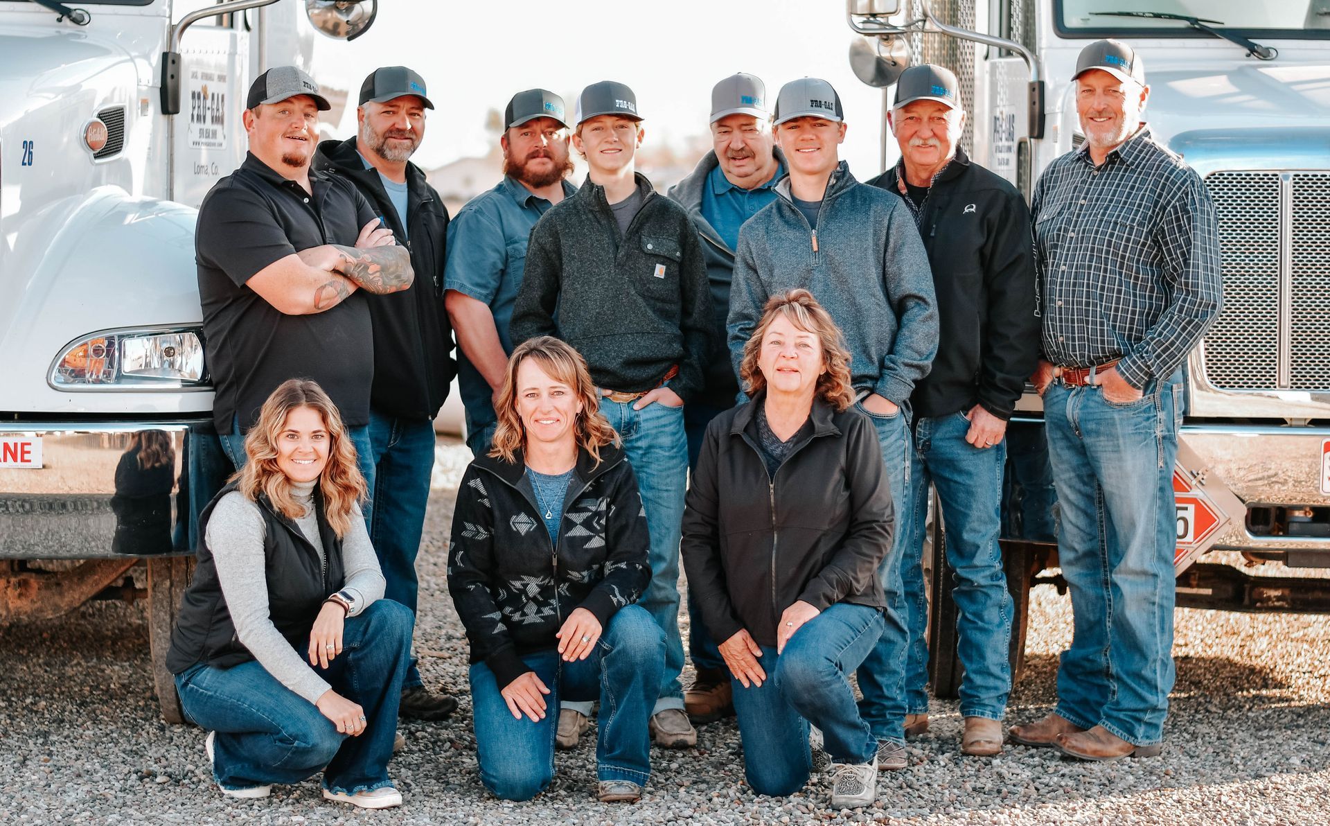White propane truck parked on gravel, under a blue sky, 