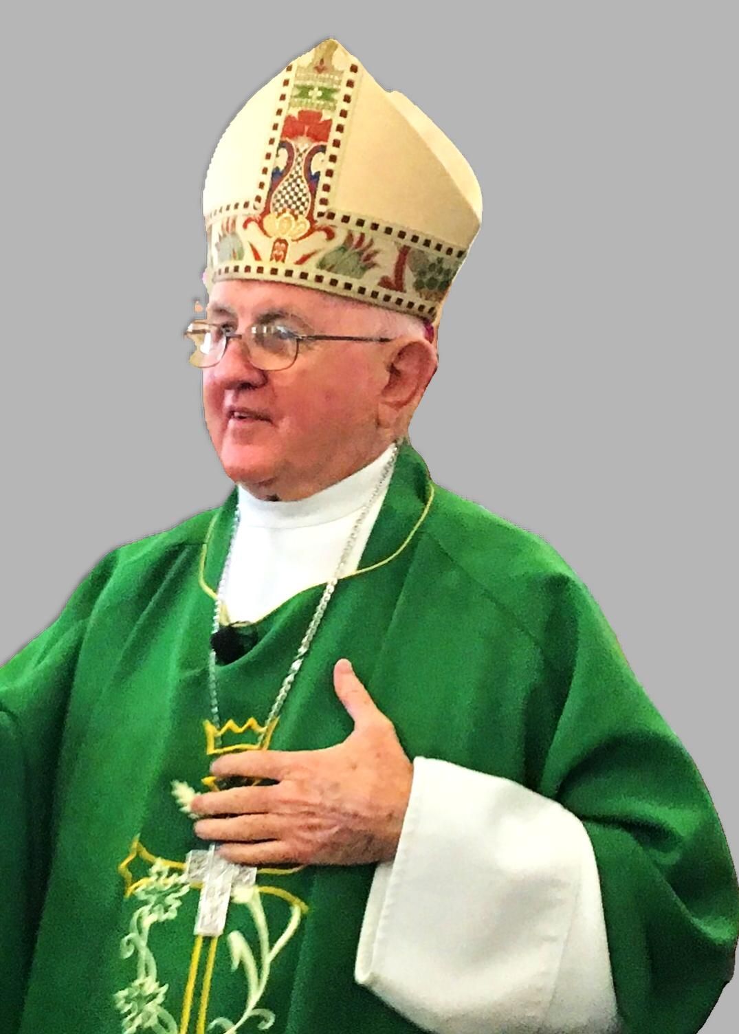 A man wearing a green robe and a white hat