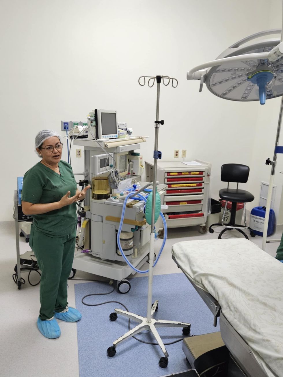 A woman in scrubs is standing in an operating room