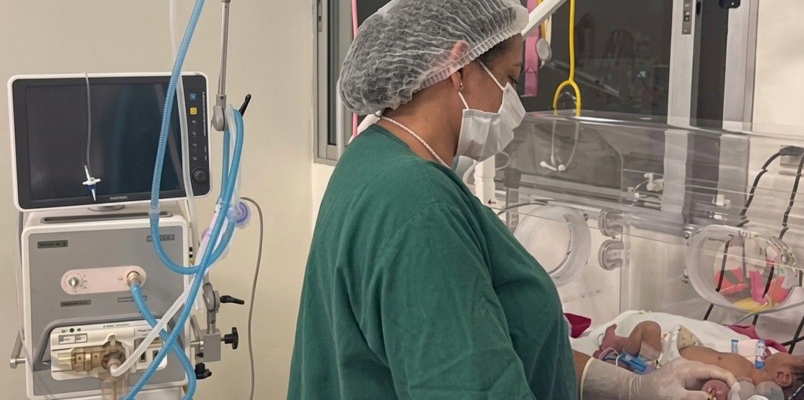 Group of people posing in a room, with a banner that reads