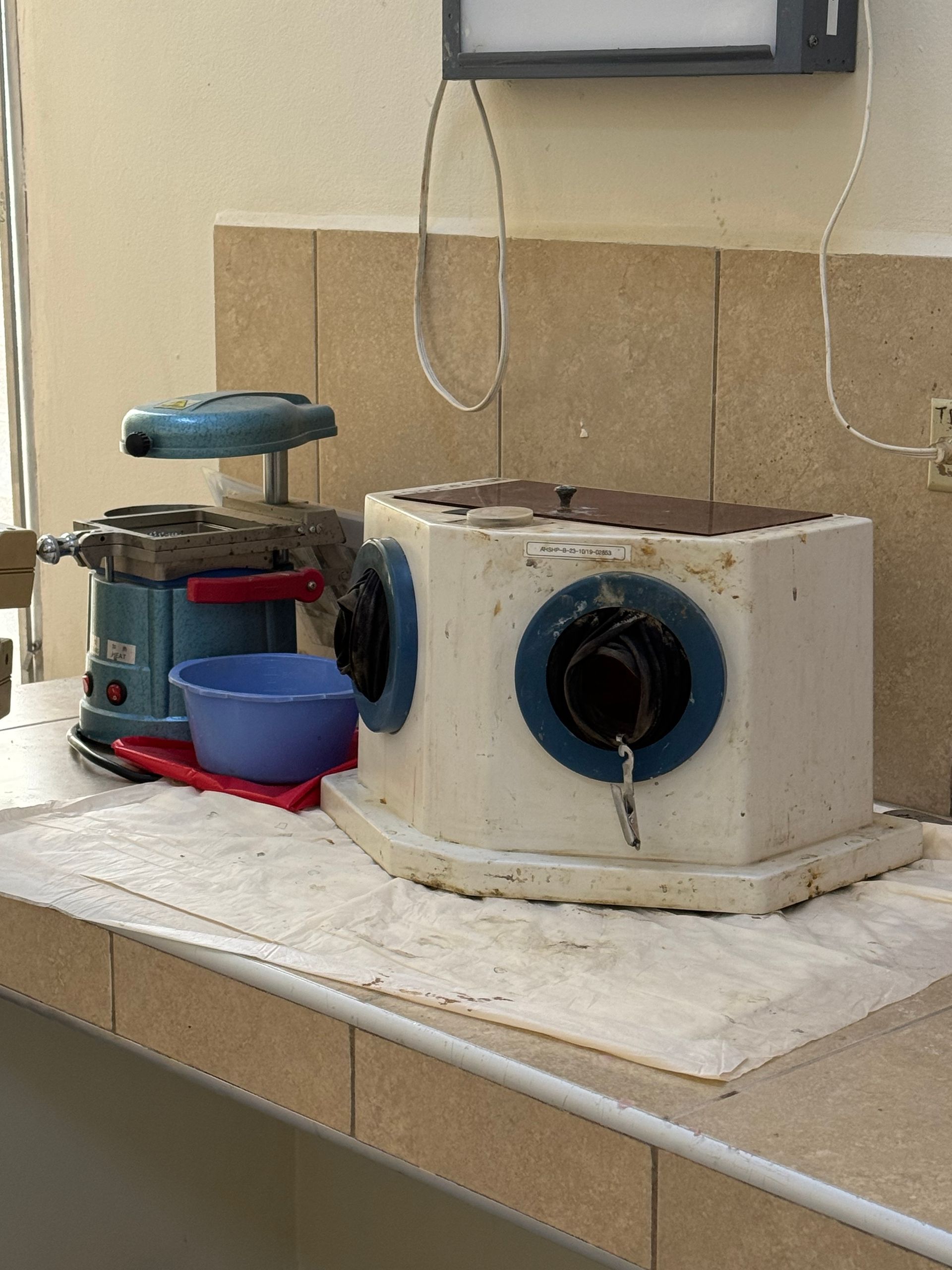 A blue and white machine is sitting on a counter next to a blue bowl