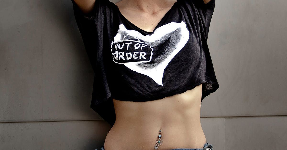 A woman is wearing a crop top that says out of order