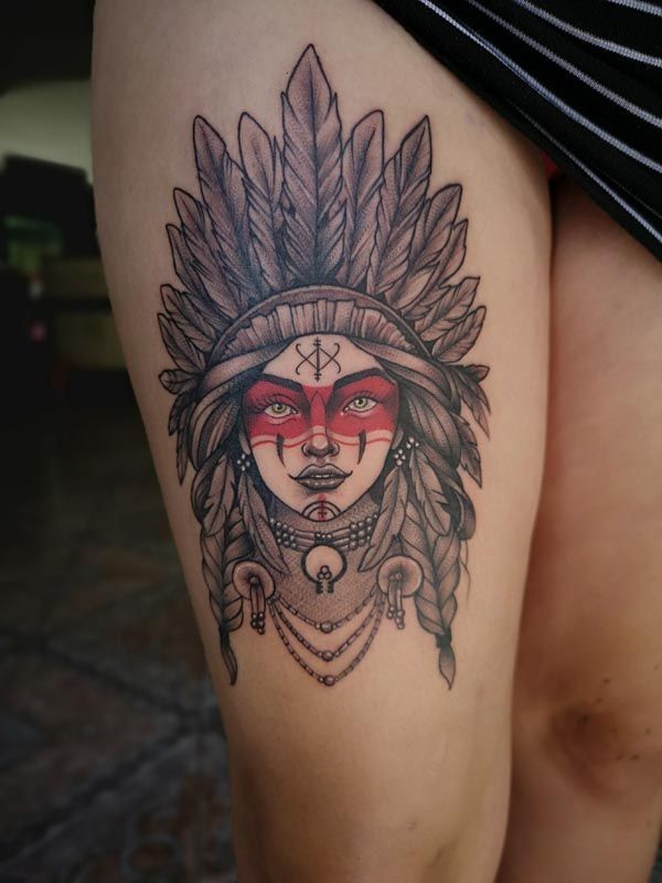 A woman has a tattoo of a native american on her thigh