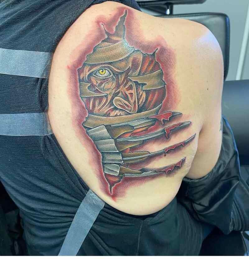 A person has a tattoo of a mummy on their back