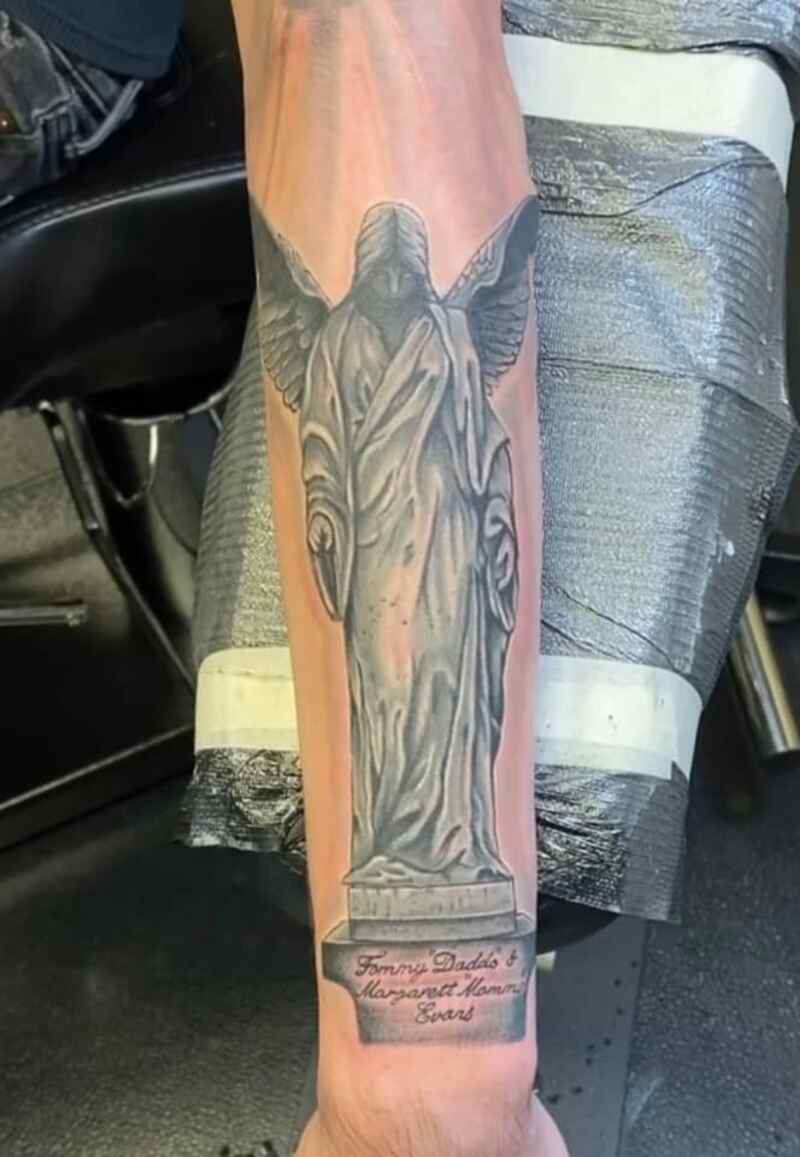A man has a tattoo of an angel on his forearm.