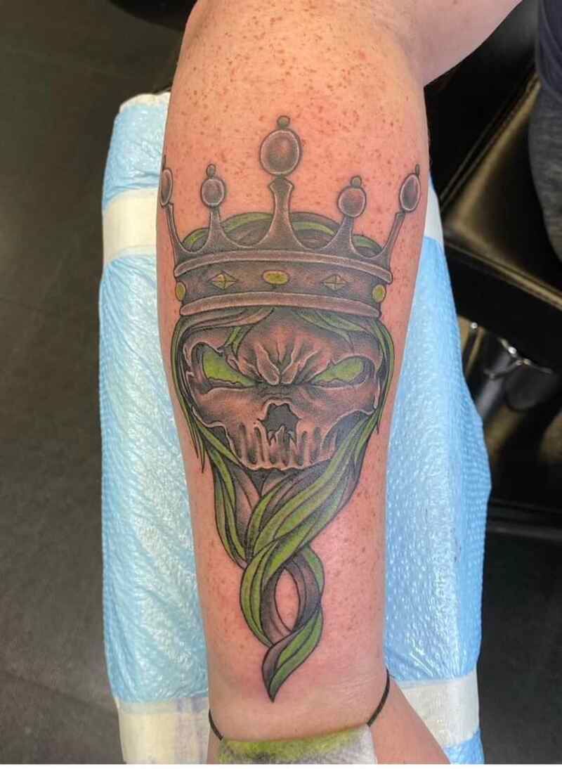 A tattoo of a skull with a crown on it