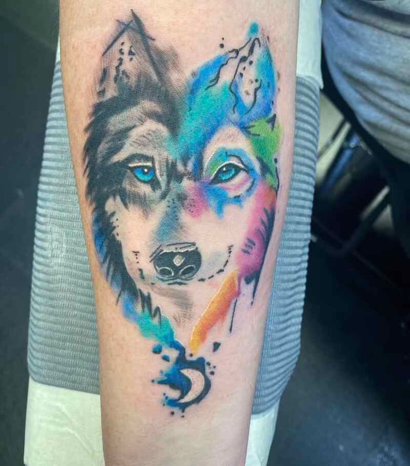A person has a colorful tattoo of a husky on their forearm