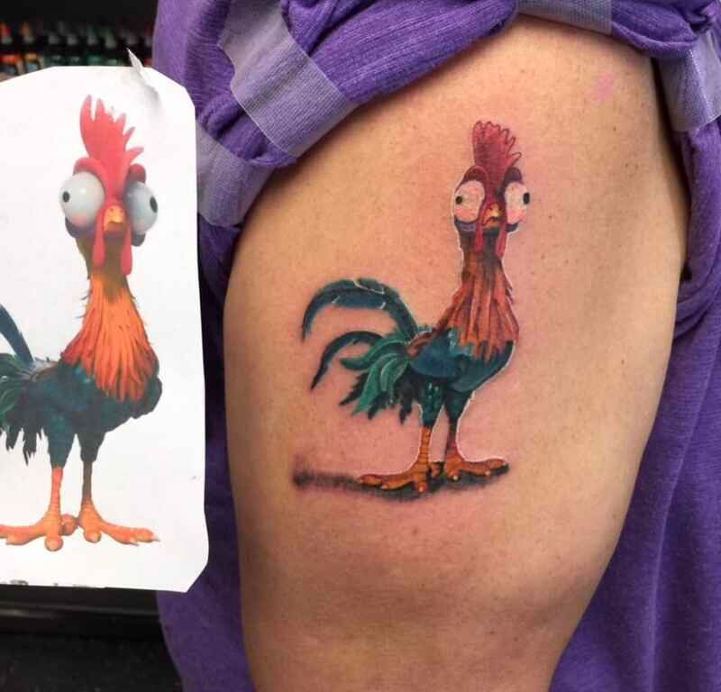 A person has a tattoo of a rooster on their thigh