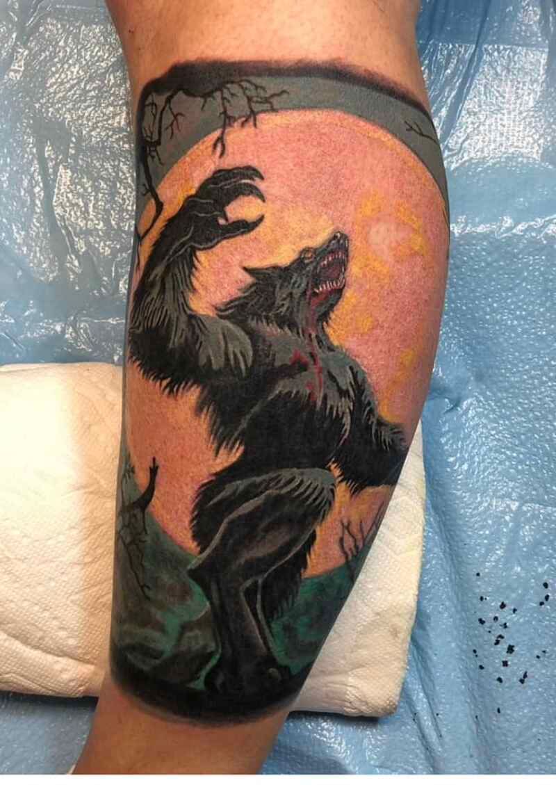 A person has a tattoo of a werewolf on their leg.