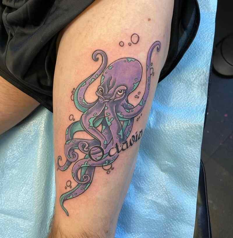 A person has a purple octopus tattoo on their leg
