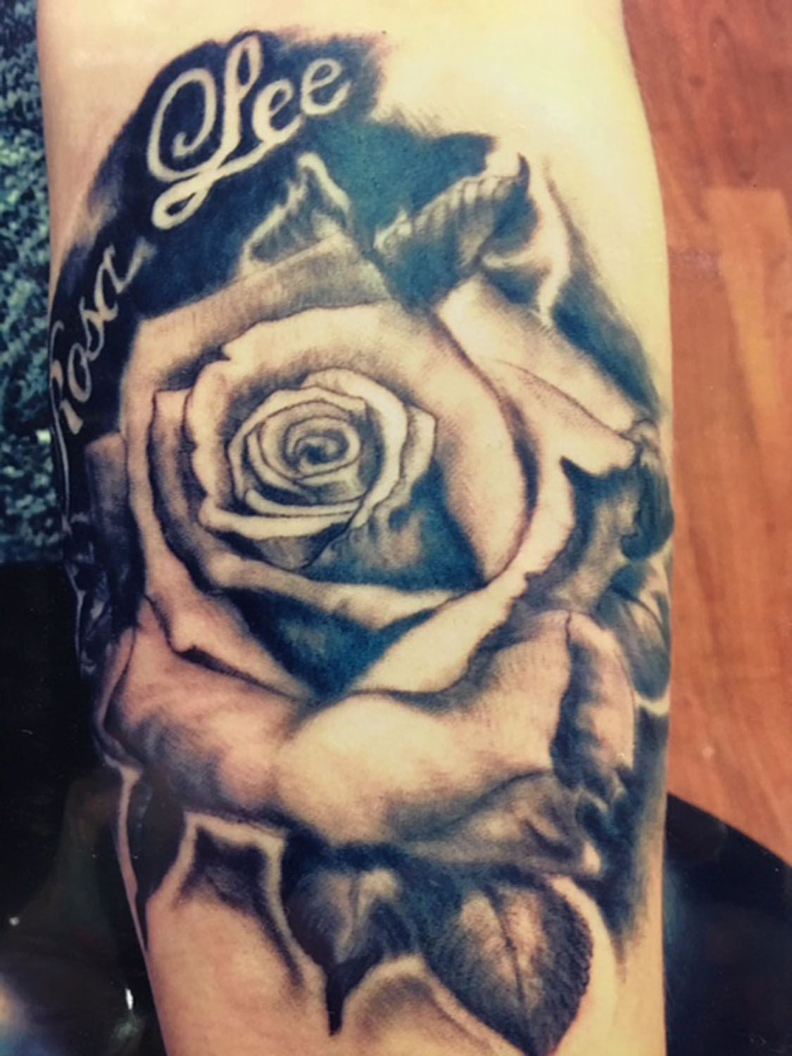 A tattoo of a rose with the name lee on it