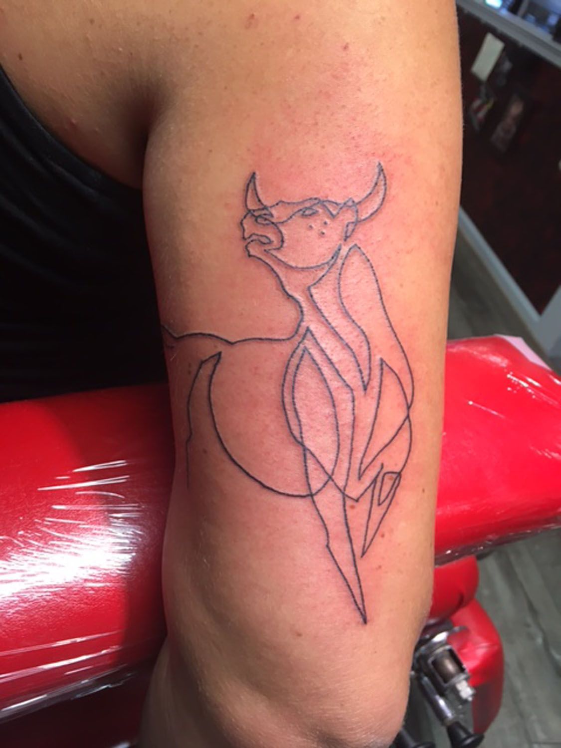 A woman has a tattoo of a bull on her arm