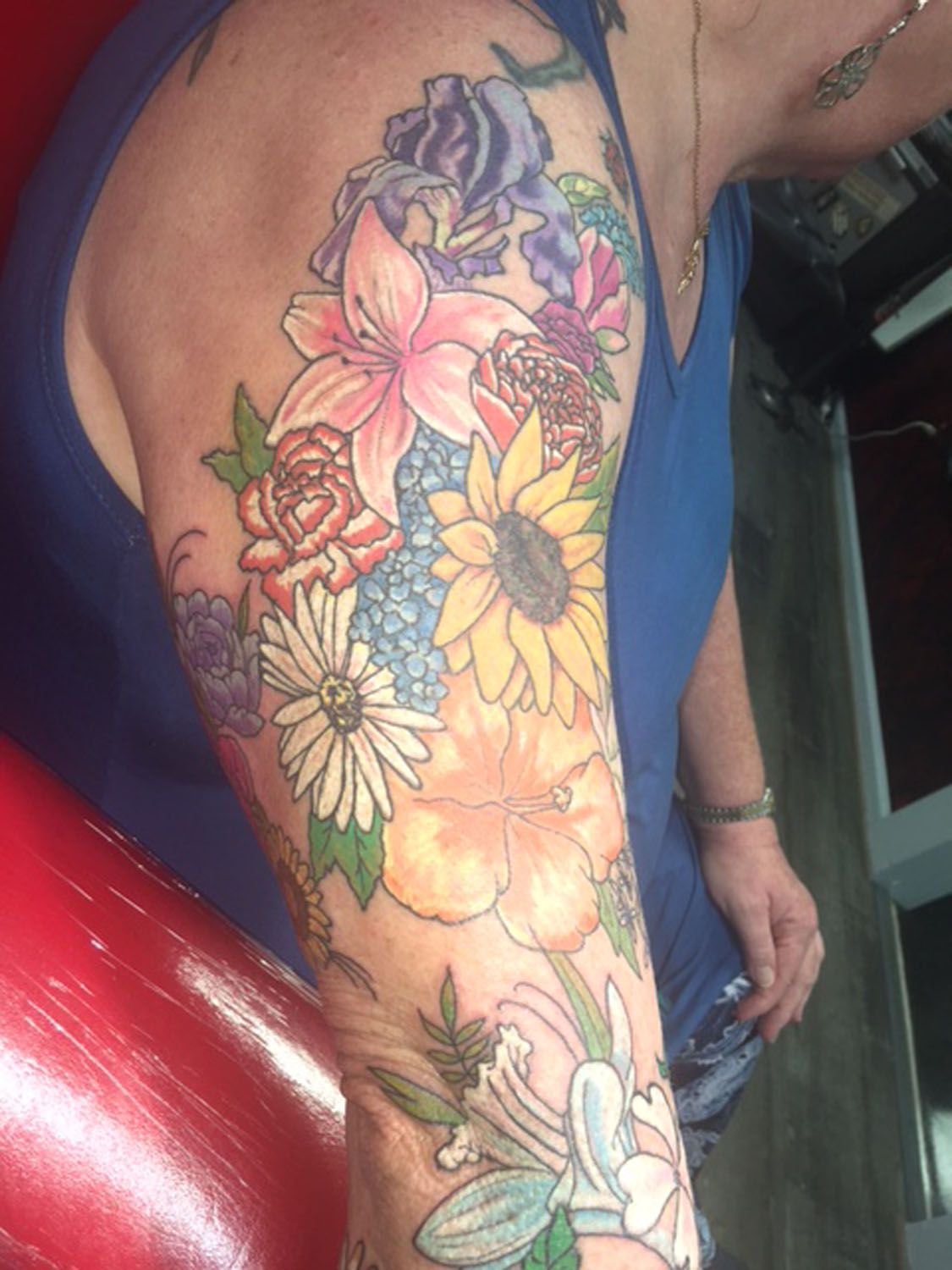A woman has a tattoo of flowers on her arm.