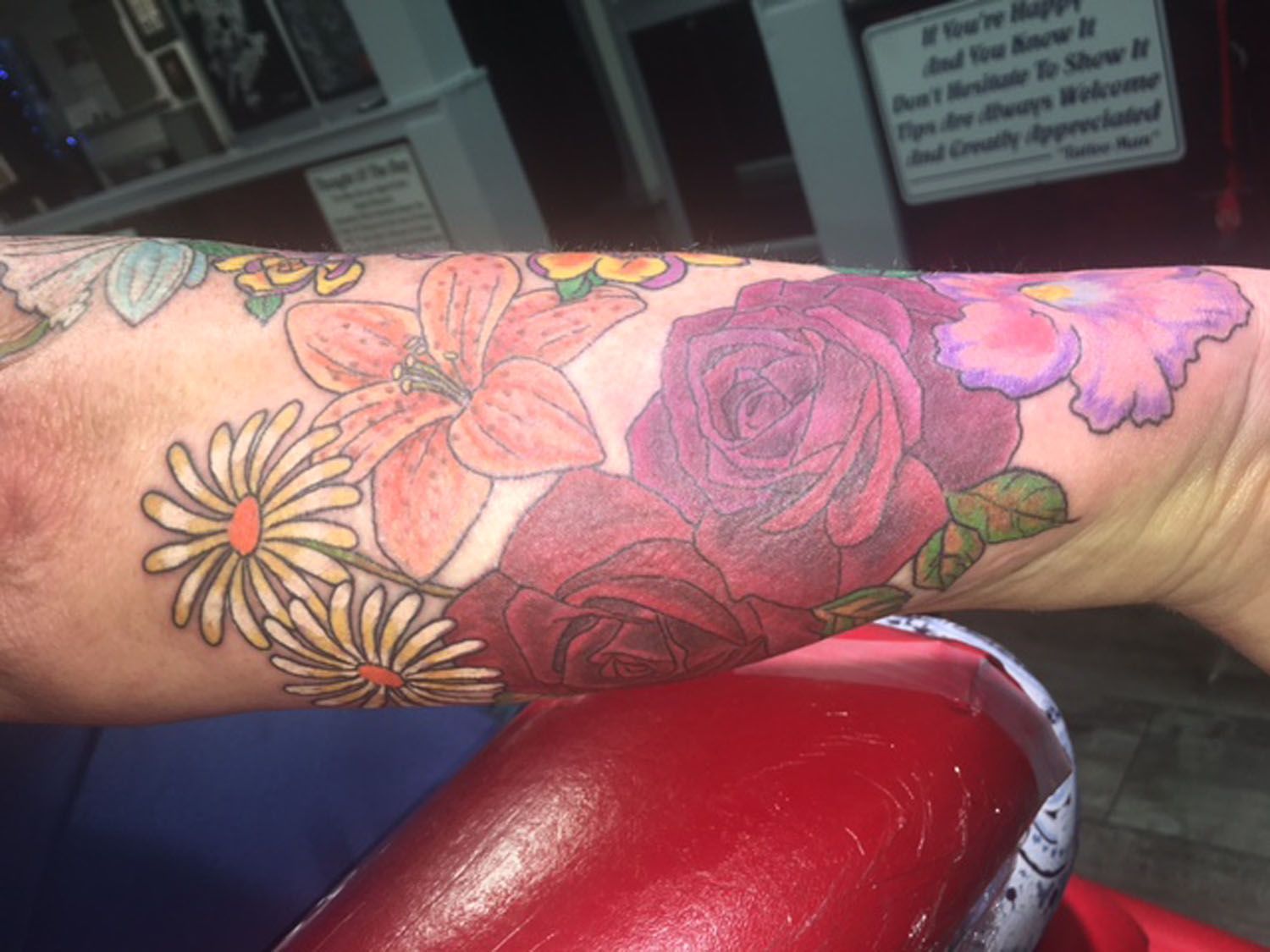A woman has a tattoo of flowers on her arm.